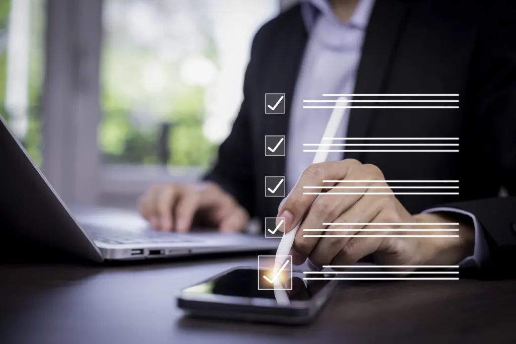 Office manager reviewing an employee offboarding checklist on a laptop