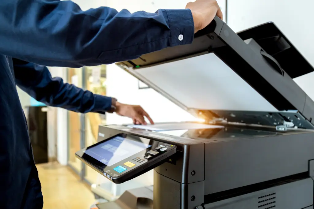 Office copier next to a server rack, representing print versus IT services
