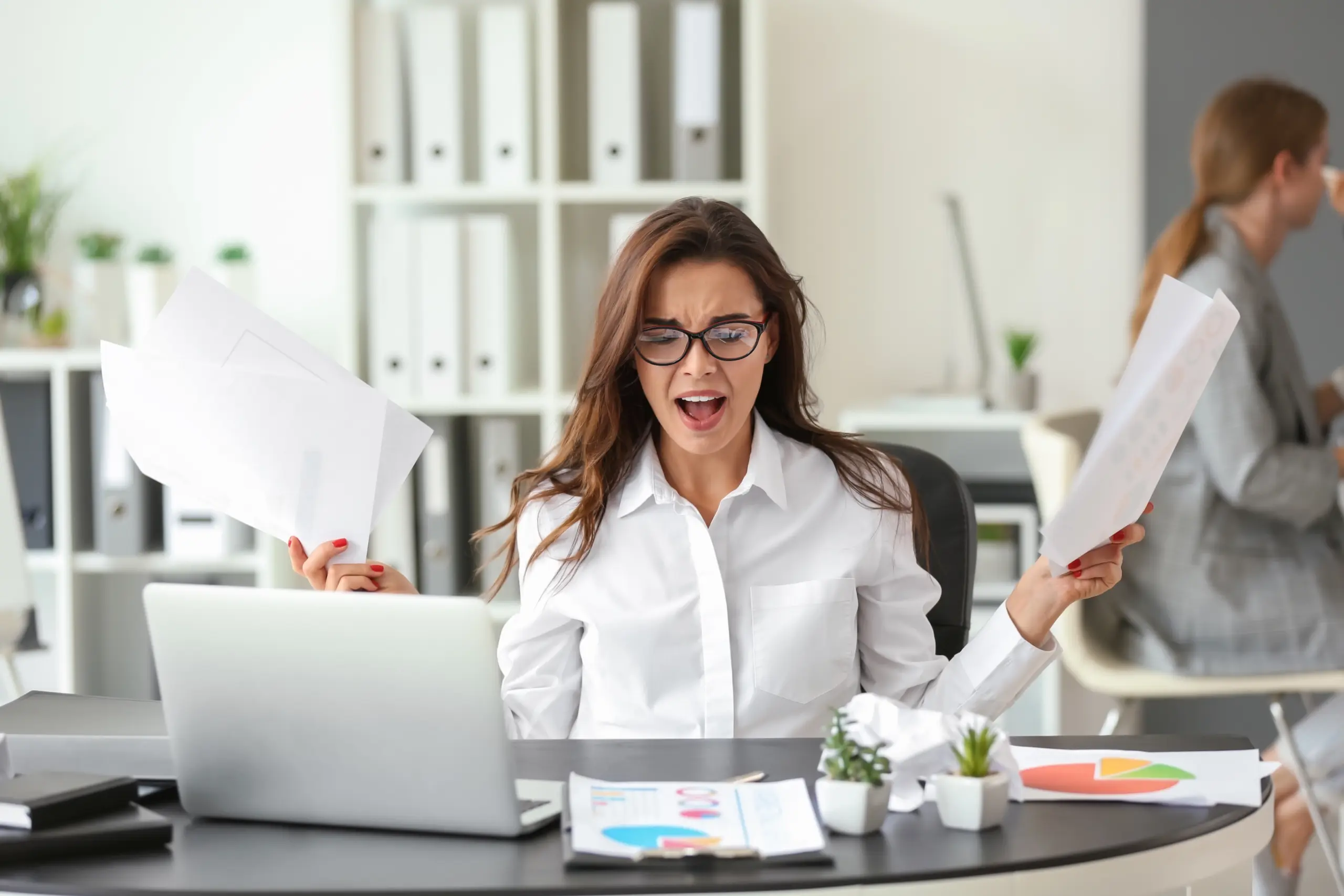 Office manager troubleshooting a computer problem at a small business desk